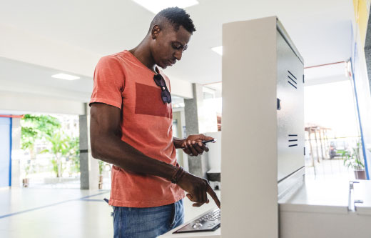 A young man using an ATM machine