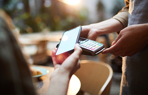 Someone paying for a meal using a mobile phone