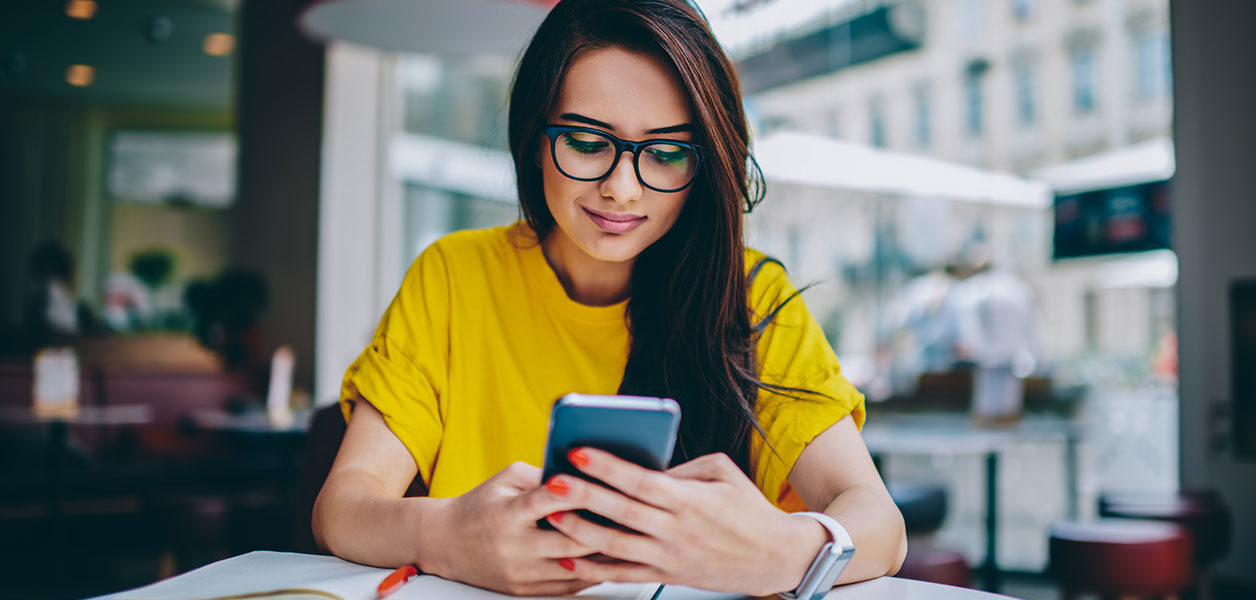 Young girl going over her checking account on her mobile phone