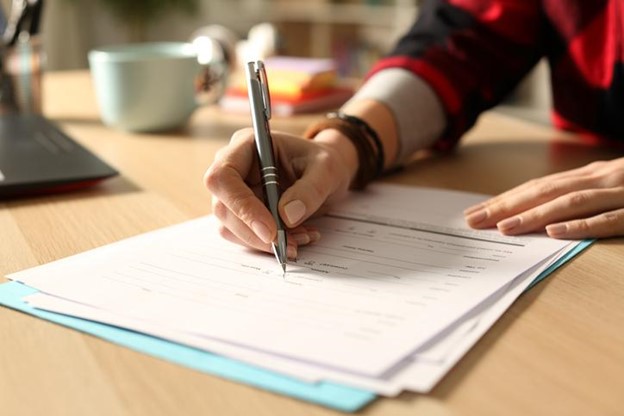 A student filling out financial paperwork at her desk.