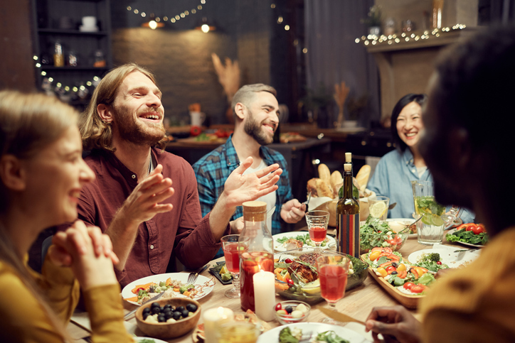 People laughing at dinner table.