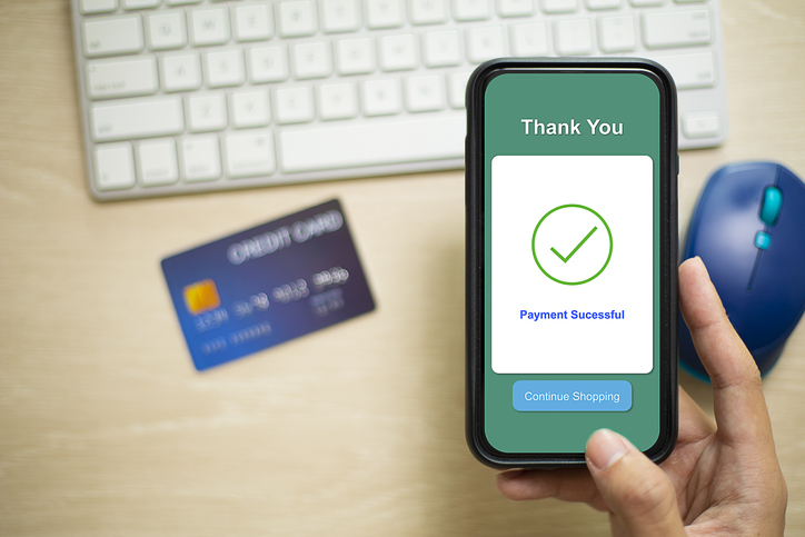 Man holding a smart phone that shows a digital wallet on its screen.